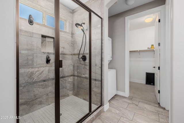 full bath featuring a stall shower, baseboards, and a walk in closet