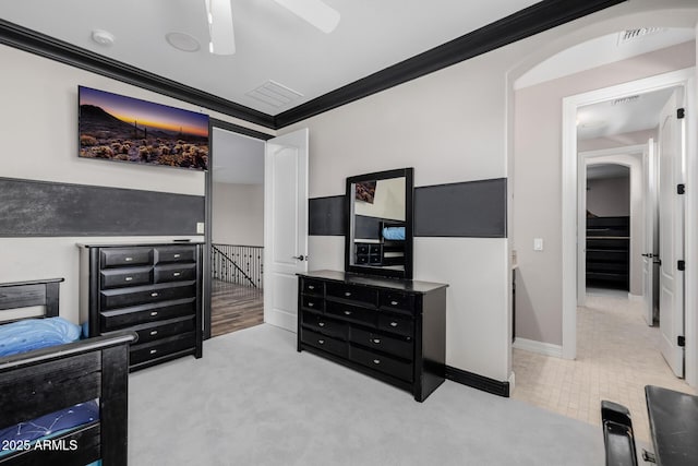 bedroom featuring carpet floors, visible vents, ornamental molding, and a ceiling fan