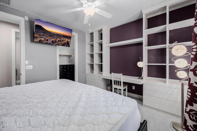 bedroom featuring built in study area, ceiling fan, and visible vents