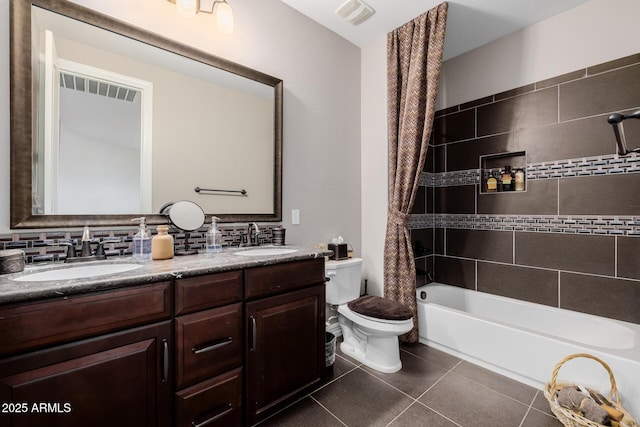 bathroom with double vanity, a sink, toilet, and tile patterned floors