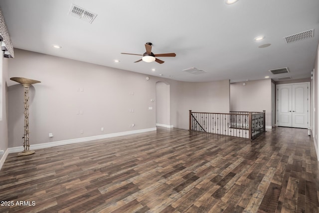 spare room with arched walkways, visible vents, and wood finished floors