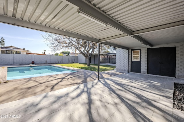 view of swimming pool with a diving board, a lawn, and a patio