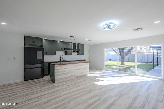 kitchen with sink, refrigerator, butcher block counters, hanging light fixtures, and tasteful backsplash