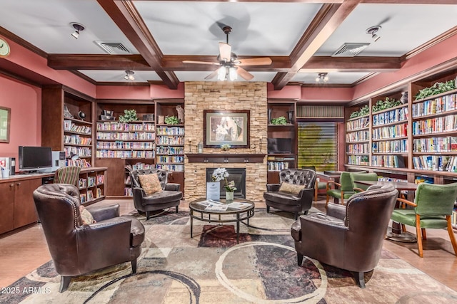 sitting room featuring coffered ceiling, ceiling fan, a fireplace, and built in features