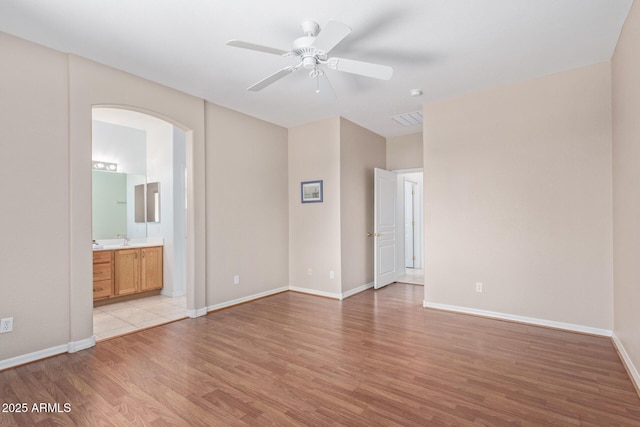 empty room featuring sink, ceiling fan, and light hardwood / wood-style flooring