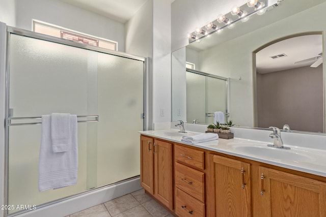 bathroom with tile patterned flooring, vanity, ceiling fan, and walk in shower