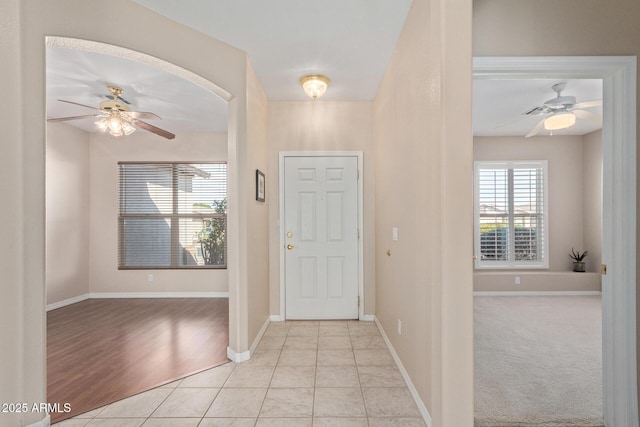 foyer entrance with light tile patterned floors and ceiling fan