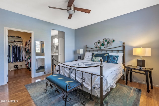 bedroom with wood-type flooring, a spacious closet, ensuite bath, and a closet