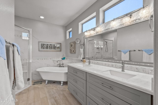 bathroom featuring tile walls, hardwood / wood-style floors, vanity, and separate shower and tub