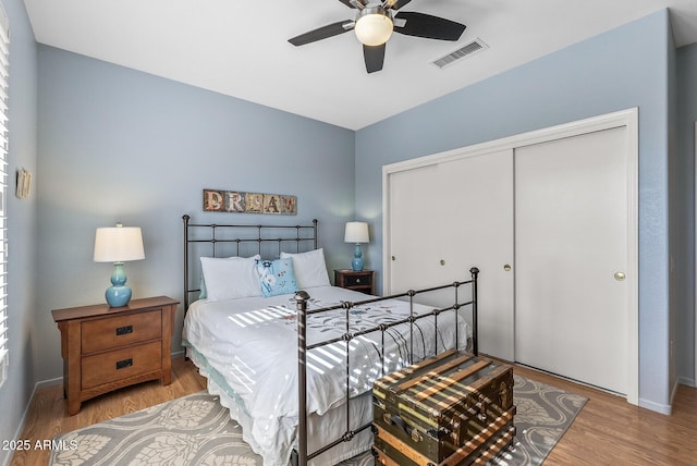 bedroom with hardwood / wood-style flooring, ceiling fan, and a closet