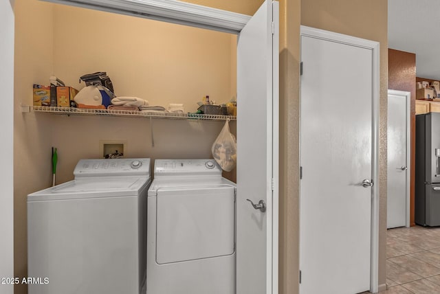 clothes washing area featuring light tile patterned floors and washing machine and clothes dryer