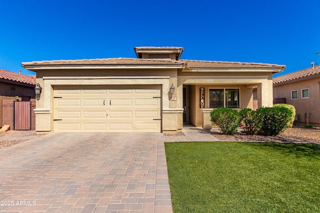 prairie-style house featuring a garage, a front yard, decorative driveway, and stucco siding