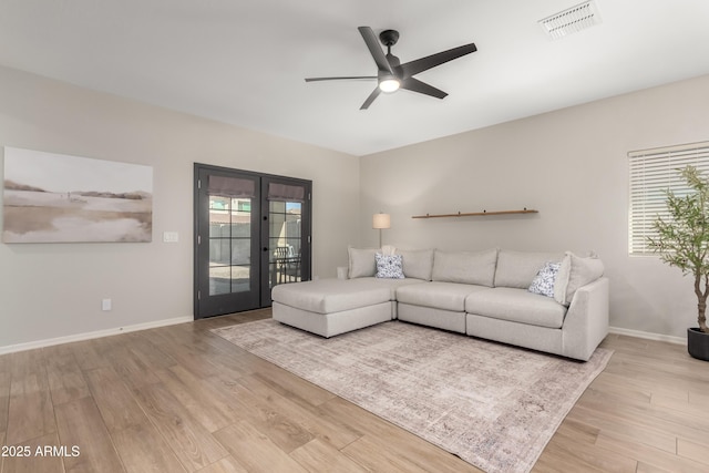 unfurnished living room featuring baseboards, visible vents, a ceiling fan, french doors, and light wood-type flooring