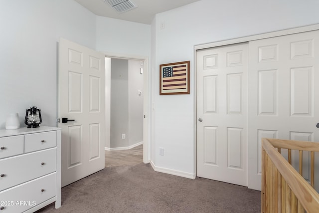 carpeted bedroom with a closet, visible vents, and baseboards