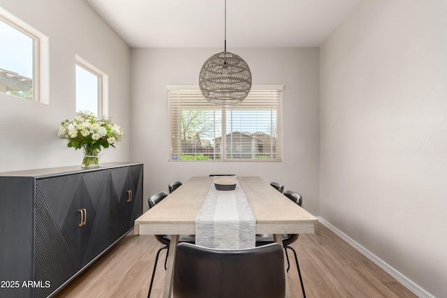 dining space with light wood finished floors and baseboards