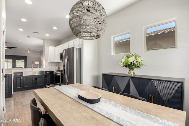 dining space with a wealth of natural light, light wood finished floors, visible vents, and recessed lighting