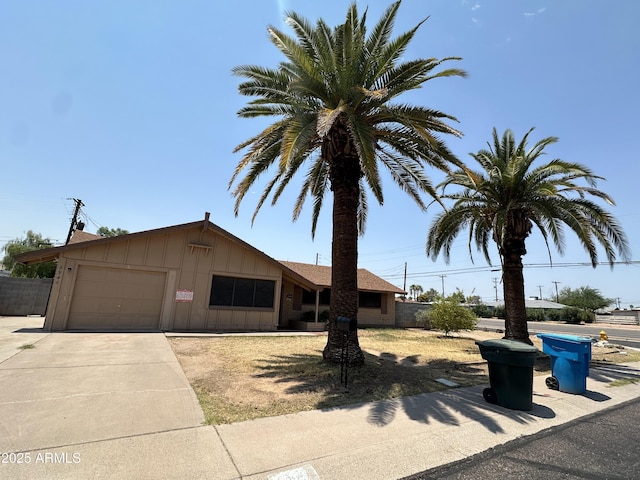 8944 N 17th Ln, Phoenix, AZ 85021 - view of front facade with board and batten siding, an attached garage, fence, and driveway
