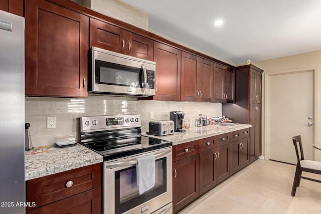 kitchen with light tile patterned floors, recessed lighting, backsplash, appliances with stainless steel finishes, and a sink