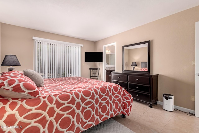 bedroom with ensuite bath, baseboards, and light tile patterned flooring