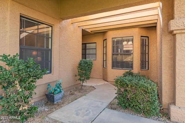 view of exterior entry with stucco siding