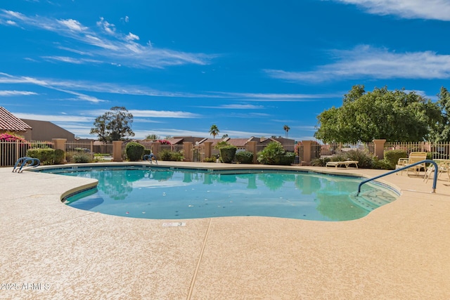 community pool with fence and a patio