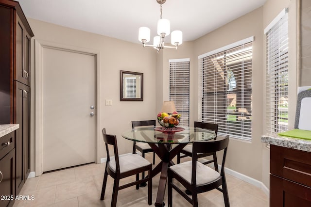 dining area featuring light tile patterned floors, baseboards, and a notable chandelier