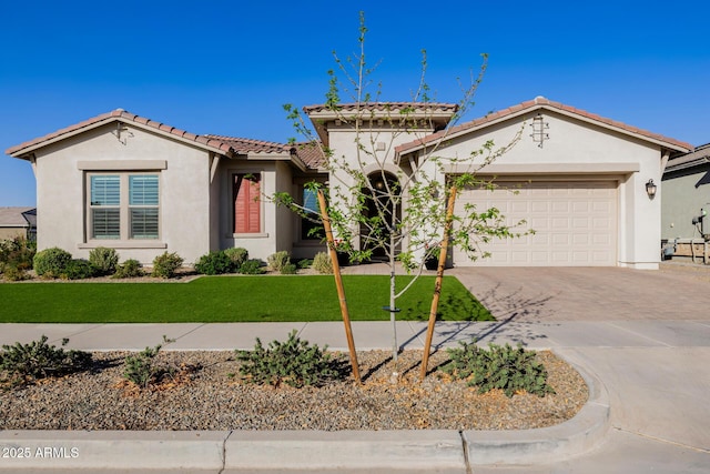 mediterranean / spanish home featuring stucco siding, a front lawn, driveway, a tile roof, and a garage