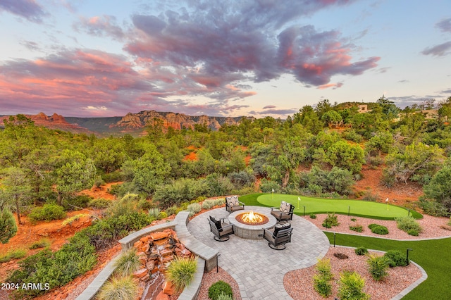 yard at dusk featuring a fire pit and a patio