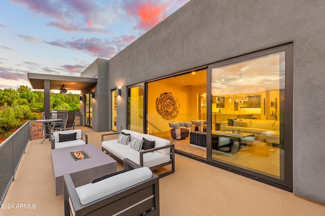 patio terrace at dusk featuring an outdoor living space with a fire pit