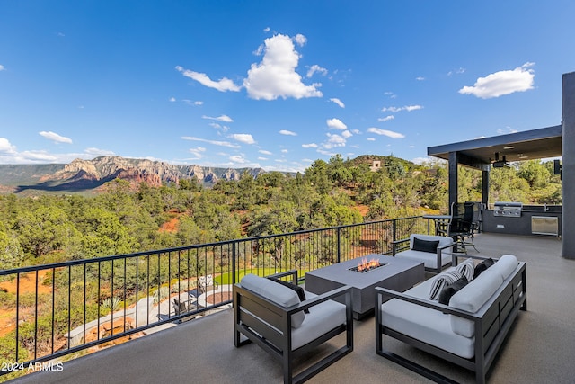 view of patio / terrace with area for grilling, an outdoor living space with a fire pit, and a mountain view