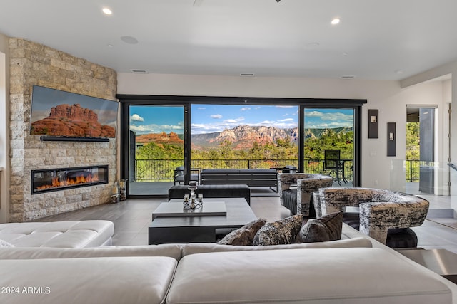 tiled living room featuring a healthy amount of sunlight and a stone fireplace