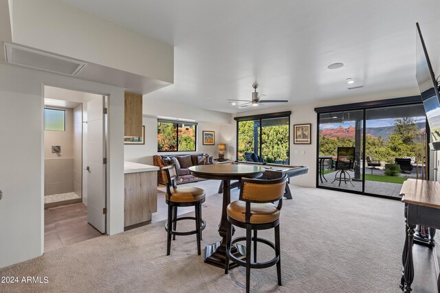 dining room with light colored carpet and ceiling fan