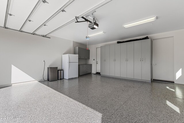 garage featuring a garage door opener and white fridge