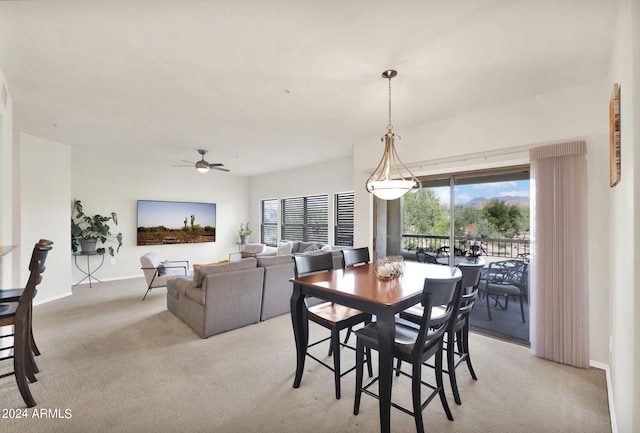 dining room with light carpet, baseboards, and ceiling fan