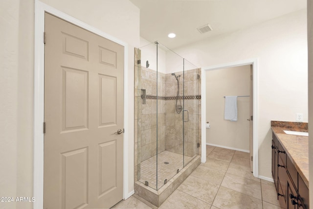 bathroom featuring tile patterned floors, visible vents, a stall shower, baseboards, and vanity