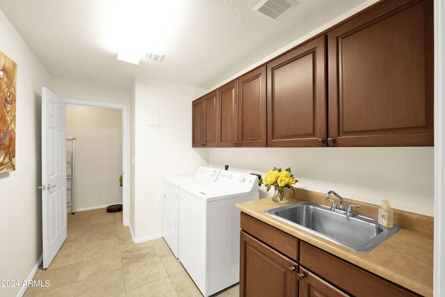 clothes washing area with visible vents, independent washer and dryer, a sink, cabinet space, and light tile patterned floors