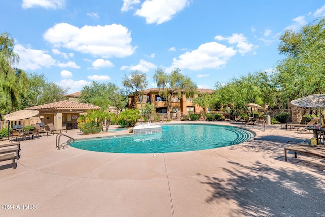 community pool with a patio and fence