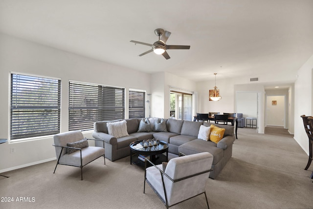 carpeted living room featuring a ceiling fan, visible vents, and baseboards