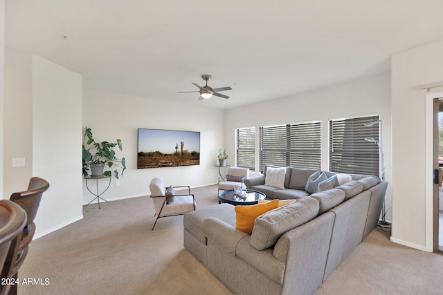 living area featuring light colored carpet, baseboards, and ceiling fan