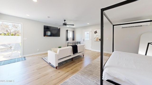 bedroom featuring light hardwood / wood-style floors, a wall unit AC, and access to outside