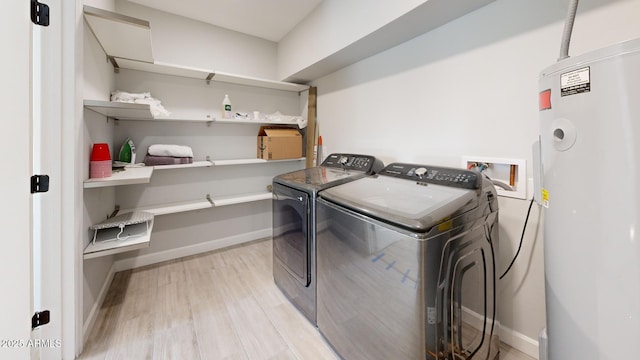 laundry area with separate washer and dryer, electric water heater, and light wood-type flooring