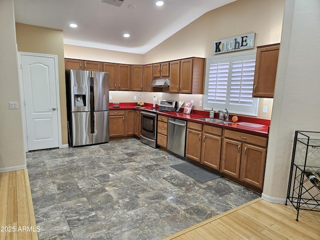 kitchen featuring stainless steel appliances, vaulted ceiling, sink, and dark hardwood / wood-style floors