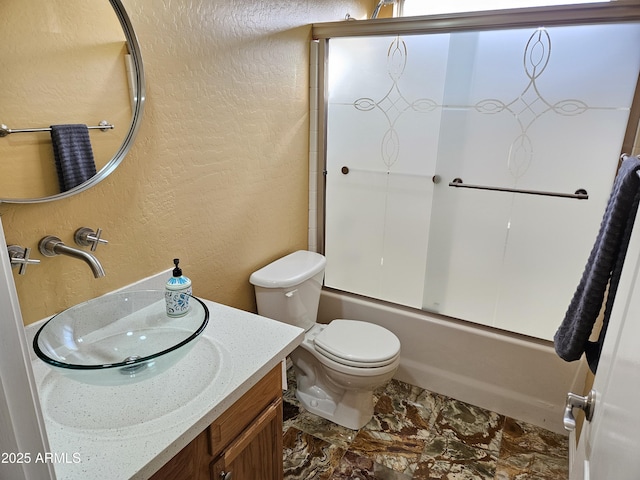 full bathroom featuring vanity, enclosed tub / shower combo, and toilet