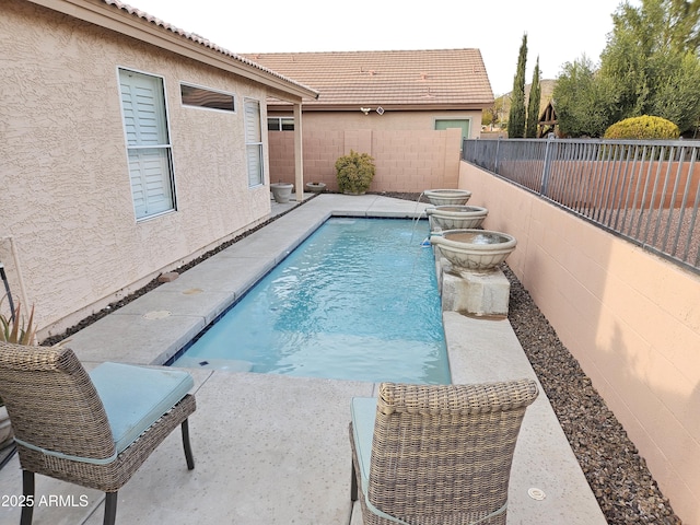 view of pool featuring pool water feature and a patio area