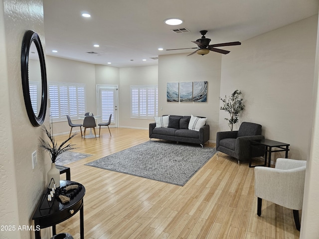 living room featuring light hardwood / wood-style floors and ceiling fan