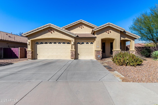 mediterranean / spanish home featuring a garage, driveway, stone siding, a tile roof, and stucco siding