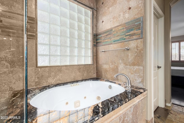 ensuite bathroom featuring a tub with jets and connected bathroom