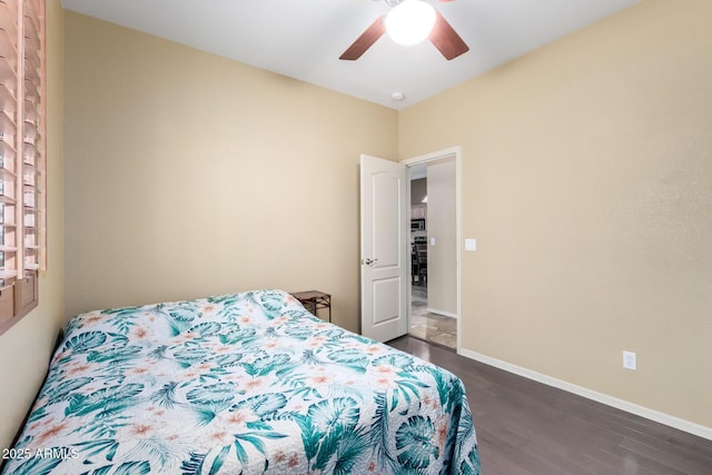 bedroom with dark wood finished floors, a ceiling fan, and baseboards