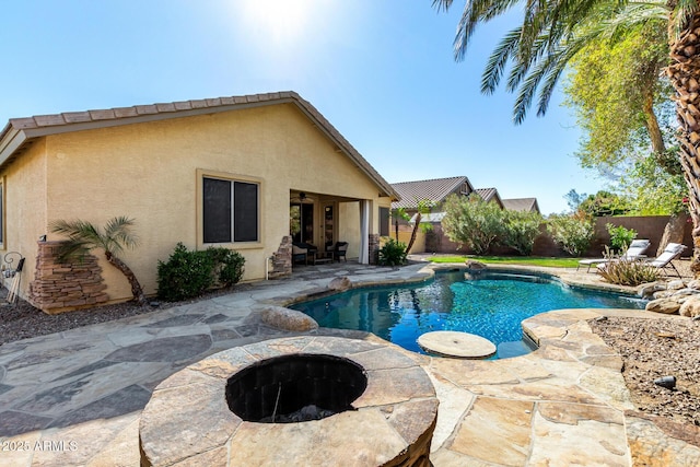 view of pool with a fenced backyard, a patio, and a fire pit