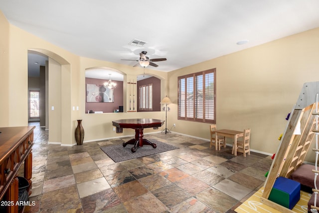 interior space featuring a wealth of natural light, stone tile floors, visible vents, and baseboards